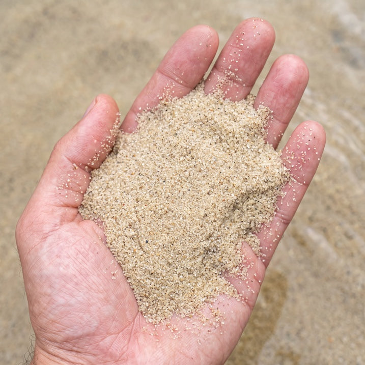Extra feiner heller Natursand in der Handfläche